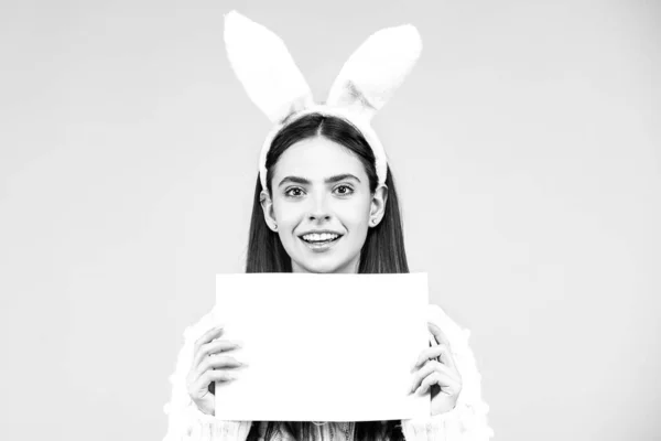 Conejita - espacio de copia, concepto de texto. Retrato de feliz conejito de Pascua mujer sostiene el papel del tablero para el texto . —  Fotos de Stock