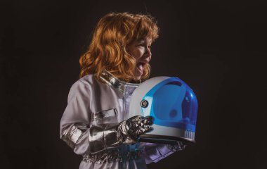 Kasklı, koruyucu uzay giysili, siyah giysili, şaşırmış küçük astronotun portresi..