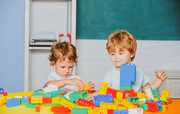 Дети играют с игрушечным поездом. Маленькие дети играют с блоками. Образовательные игрушки для дошкольного и детского сада. — стоковое фото