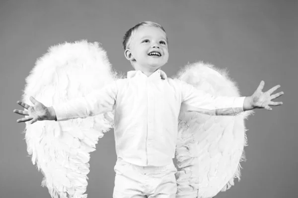 Gyermek angyalszárnyakkal elszigetelve piroson. — Stock Fotó
