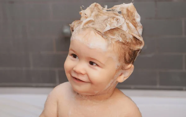 Dziecko kąpie się w wannie z pianką i bańkami mydlanymi. Zabawne dzieciaki z bliska.. — Zdjęcie stockowe