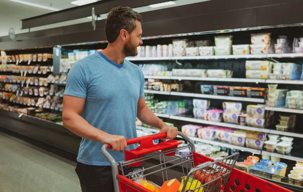 Uomo con carrello della spesa in un supermercato. — Foto Stock