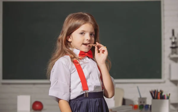 Nettes kleines Schulmädchen lernt in einem Klassenzimmer. Erster Schultag. — Stockfoto