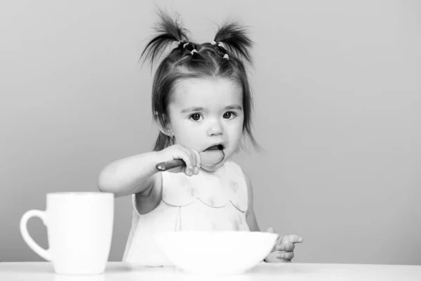 Comida de bebé gira, bebés a comer. Bebê bebê menina feliz com colher come-se. — Fotografia de Stock