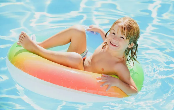 Crianças nadando com anel de natação. Criança feliz brincando com anel de natação colorido na piscina no dia de verão. Brinquedos de água de criança. As crianças brincam em resort tropical. Família praia férias. — Fotografia de Stock