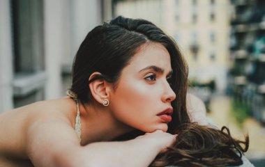 Açık havada şehvetli bir kız. Şehir moda portresi. Modaya uygun bir kadın balkonda.
