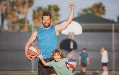 Baba oğul basketbol oynuyor. Basketbol sahasında topu olan heyecanlı bir aile..