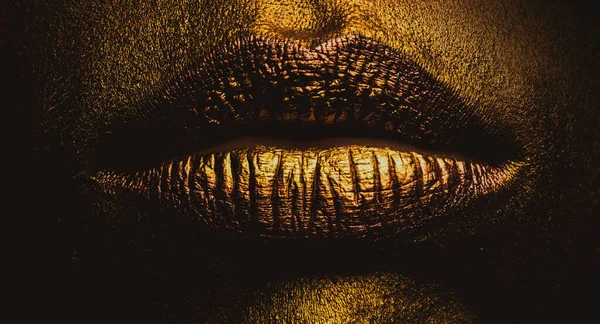 Primeros labios dorados. Labio de metal dorado. Hermoso maquillaje. Brillo labial dorado en la belleza de la boca femenina, primer plano. —  Fotos de Stock