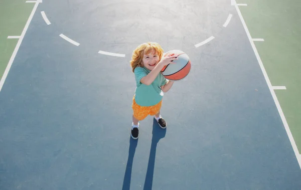 Egy kisfiú kosarazik. Gyermek sport tevékenység. Gyerekek kosárlabda iskola. — Stock Fotó