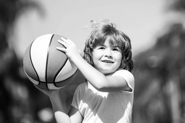 Miúdo a jogar basquetebol com bola. Criança posando com uma bola de basquete. — Fotografia de Stock