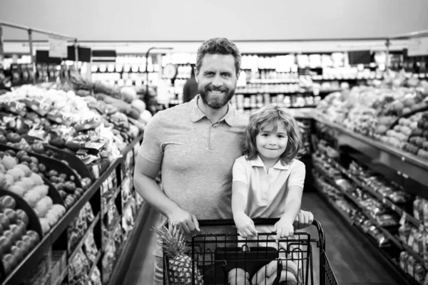 Ojciec i syn kupują świeże warzywa w spożywczaku. Rodzina w sklepie. — Zdjęcie stockowe
