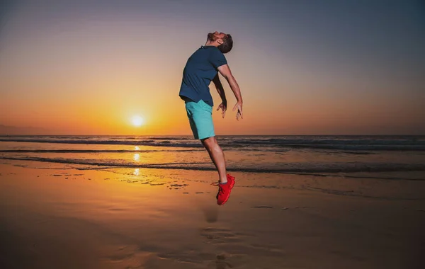 Sahilde atlayan bir adam, gün batımında siluet. İyi ve özgürlük kavramı. — Stok fotoğraf