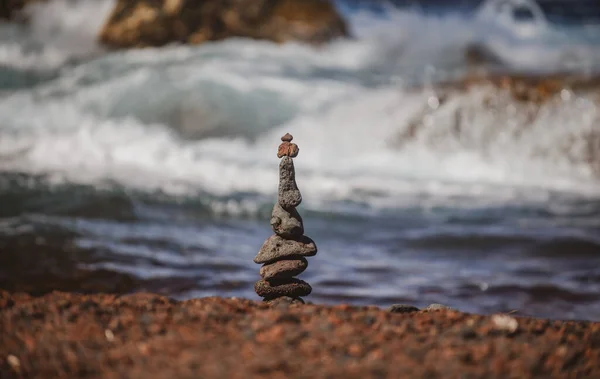 Pirâmide de pedras na praia de seixos simbolizando estabilidade, zen, harmonia, equilíbrio. — Fotografia de Stock