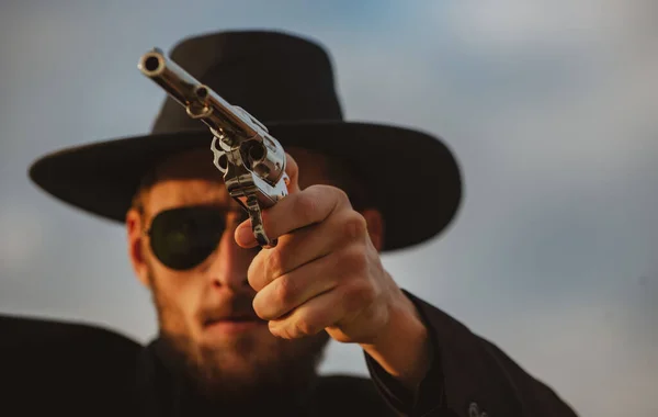 Cowboy schutter in zwart pak en cowboyhoed. Serieuze man met wilde west geweren, retro pistool revolver en marshal munitie. Amerikaanse westerse sheriff. Wilde westen gezocht concept. — Stockfoto