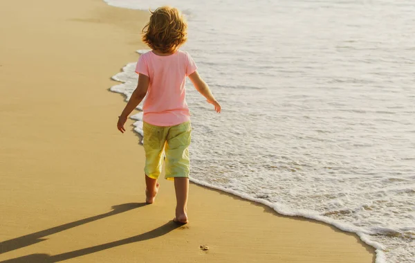 子供たちは夏のビーチで砂と遊ぶ。海で遊んでいる幸せな子供の男の子。子供は屋外で楽しんでいる。夏休みのコンセプト. — ストック写真