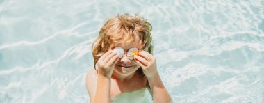 Denizde oynayan mutlu çocuk bayrağı. Çocuk sahilde eğleniyor. Yaz tatili ve aktif çocuk yaşam tarzı konsepti. Kabuklu gözler..