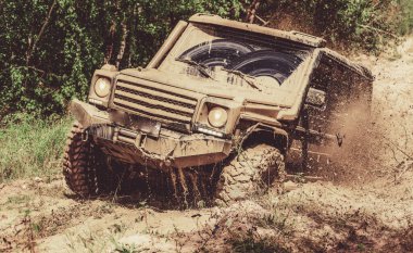 Ülke yol ve dağlar arka plan üzerinde büyük offroad araba tekerleği için alt görünümü. Büyük 4x4 araba ile seyahat konsepti. Off-road araç dağ yolunda gidiyor.