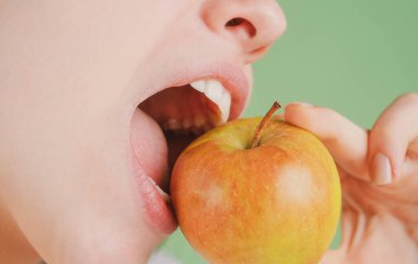 Diş konsepti. Sağlıklı beyaz dişler elmayla kapanır..