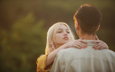 Sarılıp kucaklaşan genç aşıklar. Gün batımında sarılıp öpüşen aşıklar. Sevgi ve şefkat dolu bir çift..