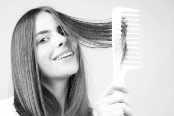 Kobieta szczotkowanie proste naturalne włosy z grzebieniem. Dziewczyna czesająca długie zdrowe włosy szczotką do włosów. Piękna koncepcja pielęgnacji włosów. Szczotkowanie włosów. — Zdjęcie stockowe