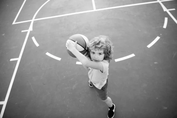 El niño se concentró en jugar baloncesto. Escuela de baloncesto para niños. —  Fotos de Stock
