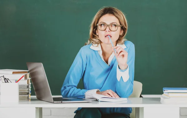 Moderno profesor atractivo. Retrato de una joven inteligente en gafas con libro en la pizarra en clase en la escuela secundaria o collage. Estudiante femenina en la universidad. Educación, escuela y personas. — Foto de Stock