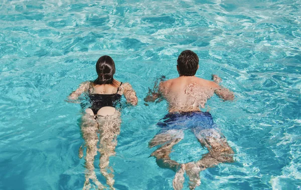 Summer couple swimming in pool. Summertime vacation. Life winner. Butt in bikini. — Stockfoto
