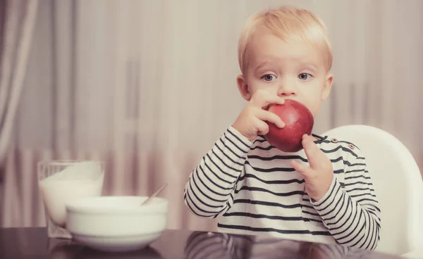 Nutrición del bebé. Come sano. Un niño comiendo bocadillos. Nutrición saludable. Concepto vitamínico. El niño come manzana. Niño lindo niño sentarse a la mesa con plato y comida. Comida saludable. Niño lindo bebé comiendo desayuno — Foto de Stock