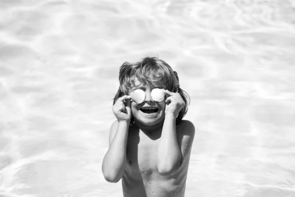 Menino brincando na piscina exterior em água azul nas férias de verão na praia tropical. Criança aprendendo a nadar na piscina de resort de luxo. — Fotografia de Stock