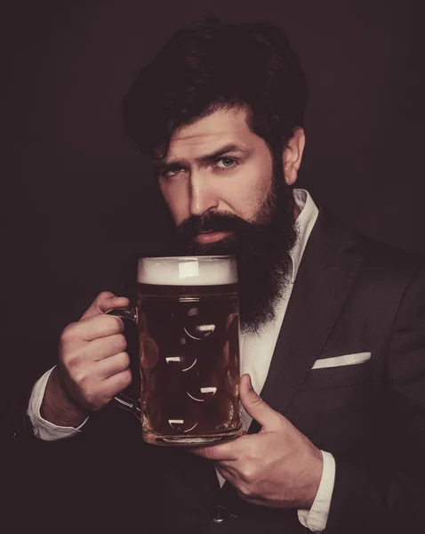 The celebration oktoberfest festival concept. Emotional funny bearded drunk hipster holds craft bottled beer. Germany - Bavaria. Bearded man with a glass of beer. — Stock Photo, Image