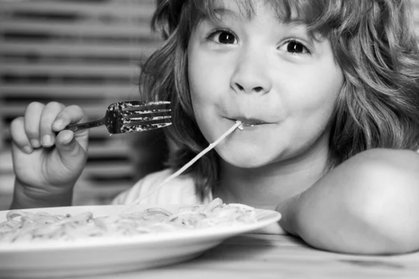 Portret van een schattig jongetje dat pasta eet, spaghetti. Sluit Kaukasische kinderen gezicht. Close-up hoofd van grappige jongen. — Stockfoto