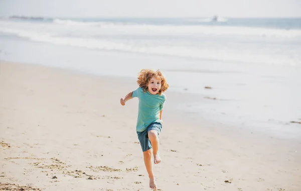 Barnpojke springer och hoppar i sommar sandstrand. — Stockfoto