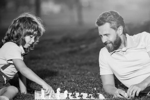 Pai e filho jogando xadrez passar tempo juntos ao ar livre. Os homens gostam de jogar xadrez. Retrato de geração masculina. — Fotografia de Stock