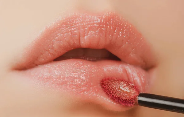 Lápiz labial de primer plano. Aplicando maquillaje en el labio. Mimos, concepto de corrección de labios. —  Fotos de Stock