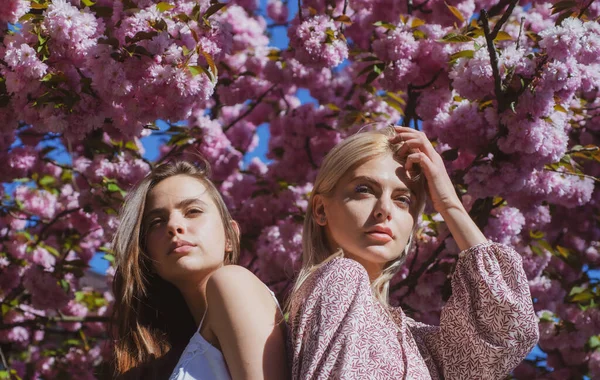 Moda de meninas de primavera. Menina bonita em flores rosa no parque de flores de verão. — Fotografia de Stock