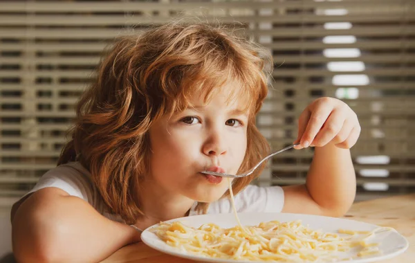 Białe dziecko jedzące makaron, spaghetti. Dzieci śmieszna twarz. — Zdjęcie stockowe