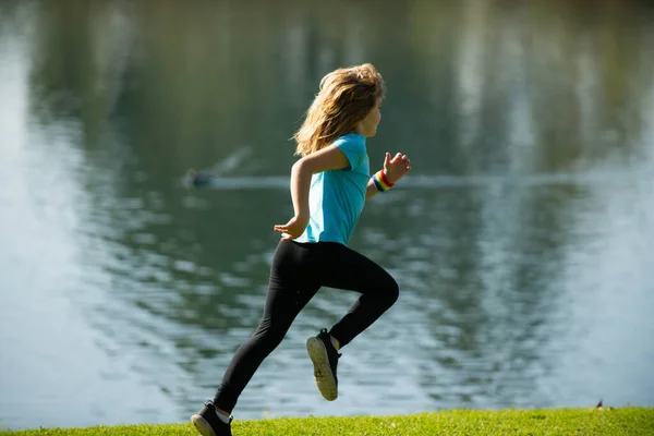 Niños corriendo en el parque al aire libre. Un niño corriendo en la naturaleza. Corredor de niño sano activo corriendo al aire libre. —  Fotos de Stock