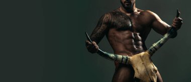 Çıplak gövdeli, kaslı, güçlü vücutlu bir adam. Boğa boynuzu. Erotik erkeksi vücutlu seksi gay. Altı paket boğa boynuzu..