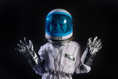 Miğferli ve koruyucu uzay giysili küçük astronot portresi. Uzay kaskıyla oynayan çocuk, küçük astronot ya da uzay adamı.