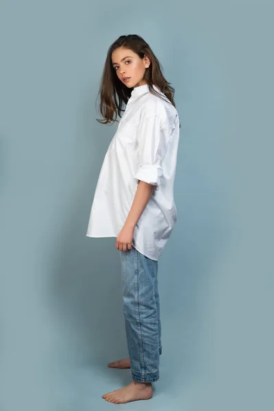 Fashion foto van een mooie jonge vrouw in shirt en jeans op studioachtergrond. Fashion model, elegante vrouw in de mode jurk poseren in de studio. — Stockfoto