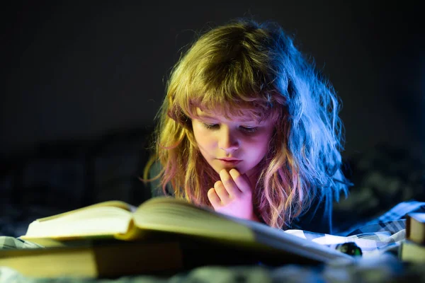 Barnboksläsning. Liten pojke läser böcker i vardagsrummet tittar på bilder i sagoboken. Grabben gör läxor för grundskolan. Fantasi eller inlärningskoncept. — Stockfoto