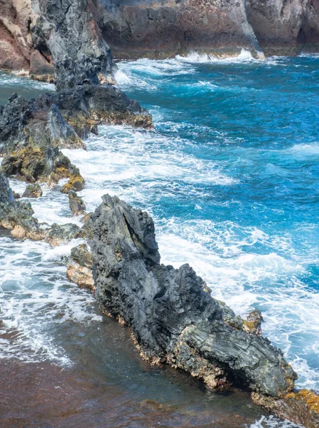 Havskust med steniga klippor. Blått vatten och stora stenar på stranden. Klippor på kusten, sommar bakgrund. — Stockfoto