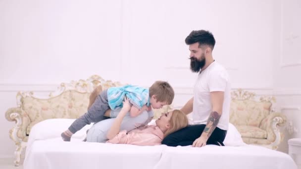 Matka otec a syn si hrají v posteli. Rodičovský koncept. — Stock video