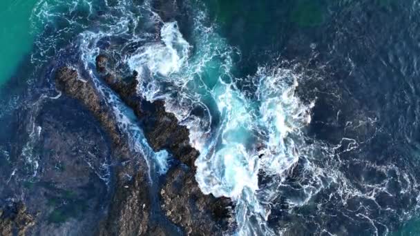 Las olas del océano chocan contra piedras. Salpicaduras de agua con espuma en las olas. — Vídeo de stock