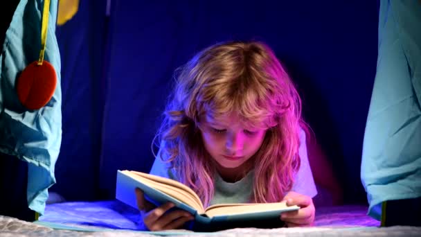 Kinder lesen Bücher. Kind liest Geschichte mit Buch. Kind liest vor dem Schlafengehen ein Buch im Bett. — Stockvideo