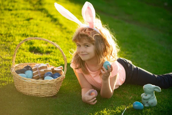 Kinderen vieren Pasen. Kind in konijnenkostuum met konijnenoren buiten. Grappige jongen, paashaas kinderen. — Stockfoto