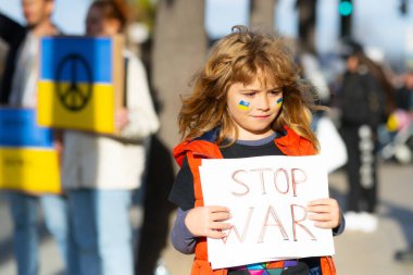 Ukrayna bayrağı ve poster savaşını protesto eden küçük bir çocuk. Çocuklar protesto ediyor. Eylemcilik kavramı.