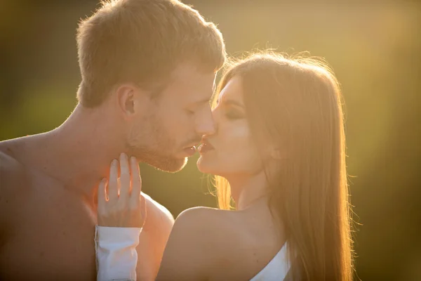 Un beso sensual. El hombre besó a la tierna mujer. Retrato de una encantadora pareja enamorada. Joven novia sensual contenta de beso apasionado de su novio. Hombre joven guapo abraza a la mujer y besos al atardecer. —  Fotos de Stock