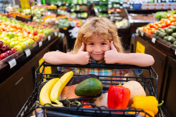 Kindereinkauf im Supermarkt. Junge kauft im Supermarkt ein. — Stockfoto