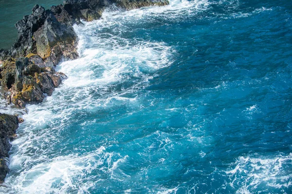 Kustlandschap met blauwe zee en prachtige kliffen. Stenen rotsen aan de kust in blauw water. — Stockfoto